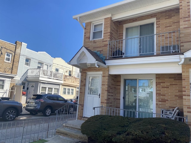 view of front of property with a balcony and brick siding