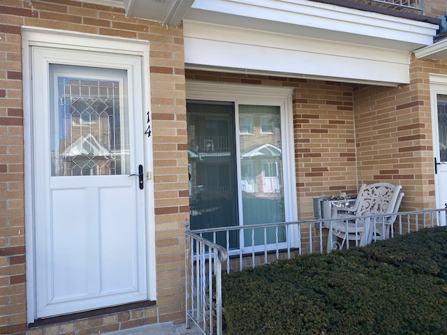 view of exterior entry featuring brick siding