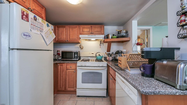 kitchen with brown cabinetry, white appliances, under cabinet range hood, and light tile patterned floors