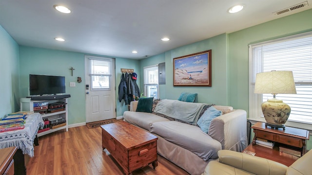 living area featuring baseboards, wood finished floors, visible vents, and recessed lighting