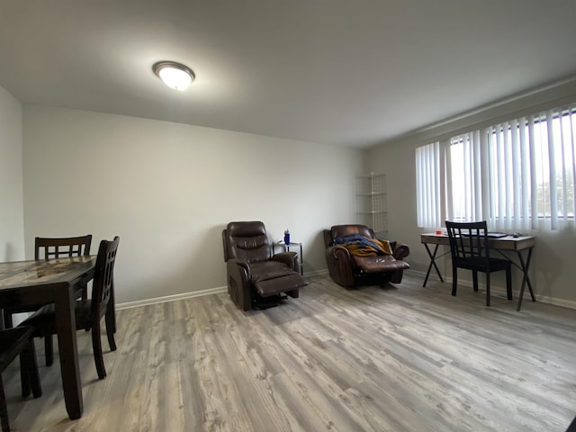 dining room featuring light wood-style flooring and baseboards