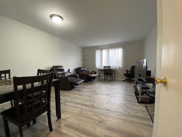 dining area with light wood-style floors and baseboards