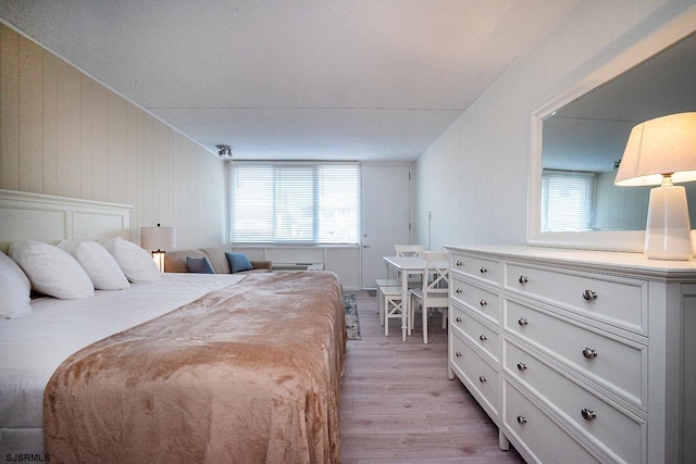 bedroom with multiple windows and light wood-type flooring