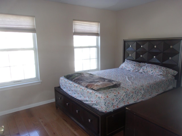 bedroom featuring baseboards and wood finished floors