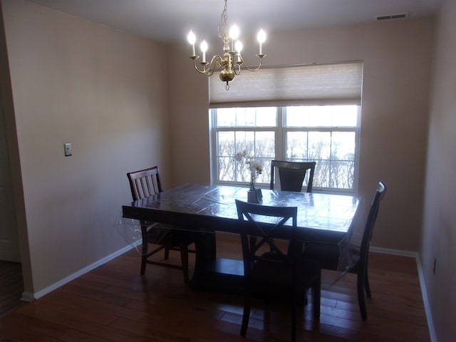 dining area with dark wood-style flooring, visible vents, baseboards, and an inviting chandelier