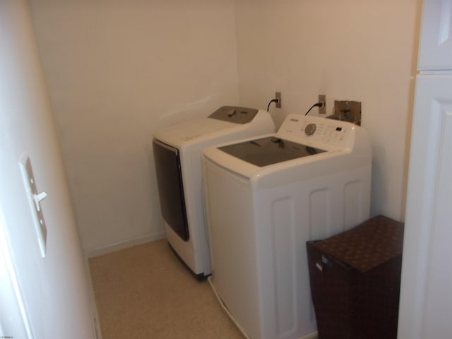 washroom featuring laundry area, baseboards, and separate washer and dryer