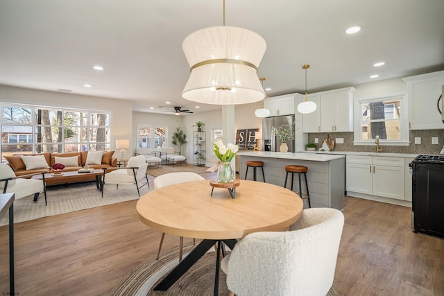 dining space with light wood-type flooring, visible vents, ceiling fan, and recessed lighting