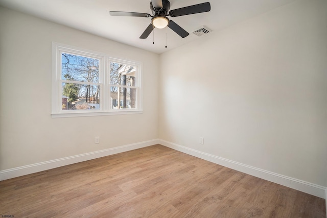 unfurnished room with light wood-style floors, visible vents, baseboards, and a ceiling fan