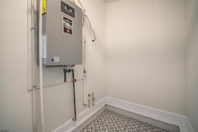 washroom featuring laundry area, water heater, and baseboards