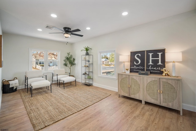 living area with light wood-style floors, recessed lighting, visible vents, and baseboards