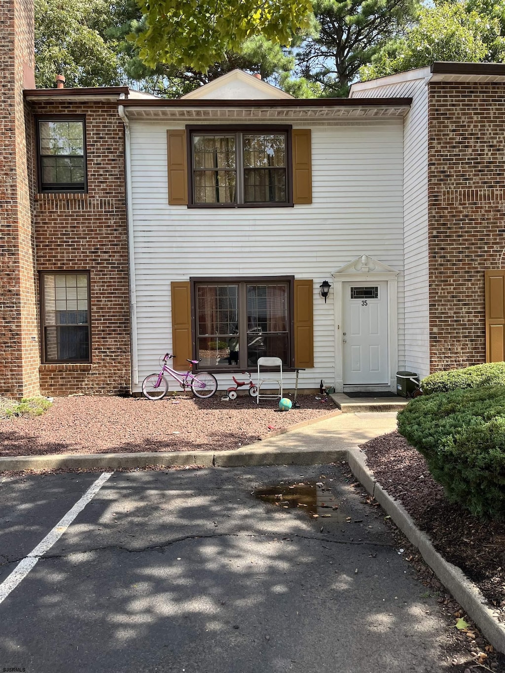 view of front of house with uncovered parking and brick siding