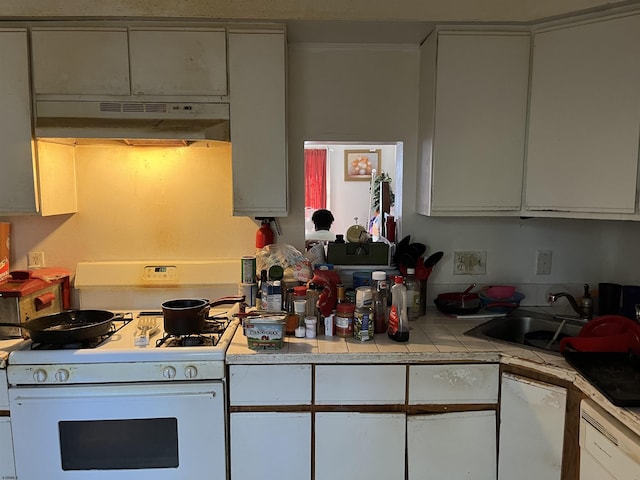 kitchen featuring white appliances, white cabinetry, under cabinet range hood, and tile countertops