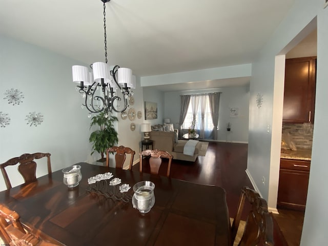 dining room featuring dark wood-style floors, baseboards, and an inviting chandelier