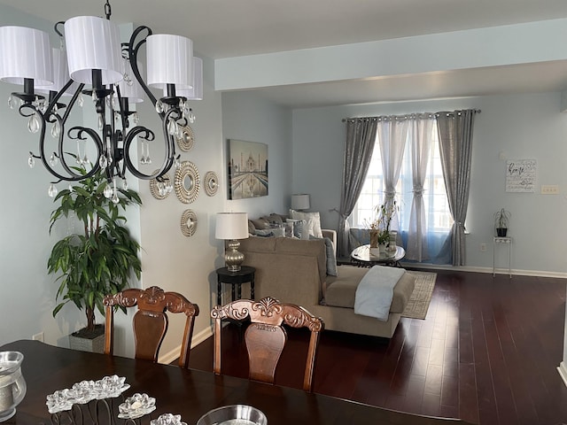 living room with baseboards, dark wood finished floors, and a notable chandelier