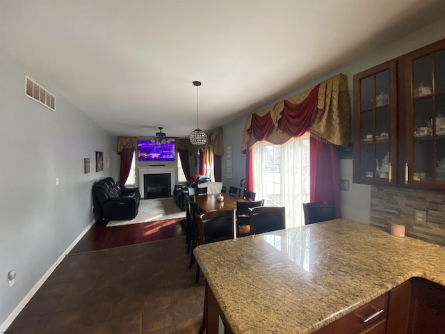 kitchen featuring light countertops, glass insert cabinets, a fireplace, and visible vents