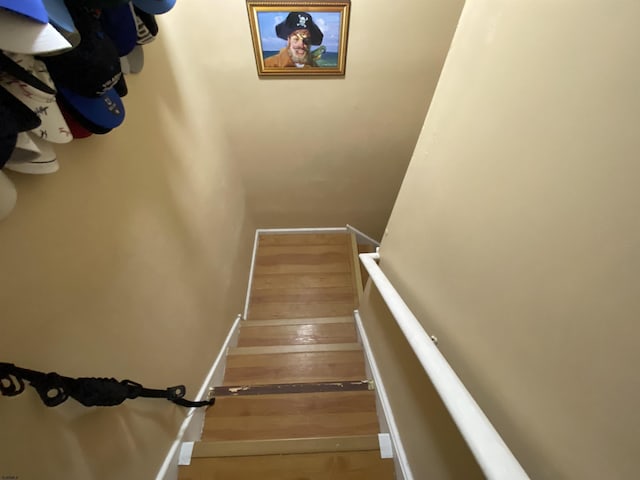 staircase featuring wood finished floors and baseboards