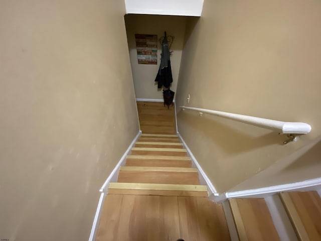 staircase with baseboards and wood finished floors