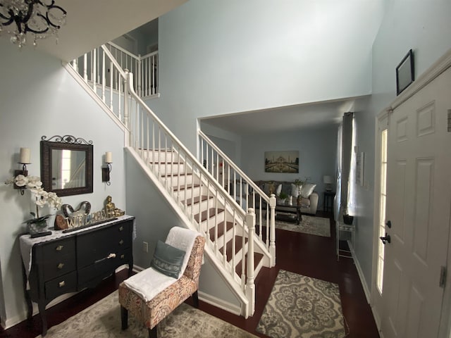 entrance foyer with dark wood-style floors, baseboards, a high ceiling, and stairway