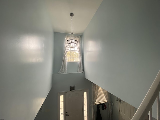 staircase with a chandelier