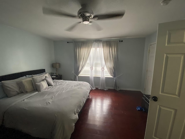 bedroom featuring ceiling fan, dark wood finished floors, and baseboards