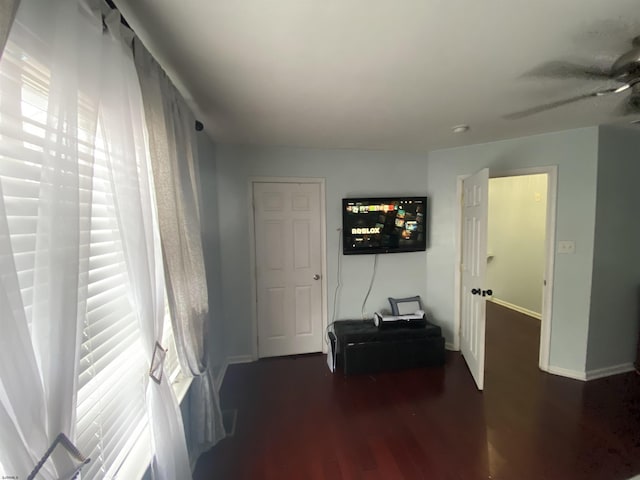 interior space featuring baseboards and dark wood finished floors