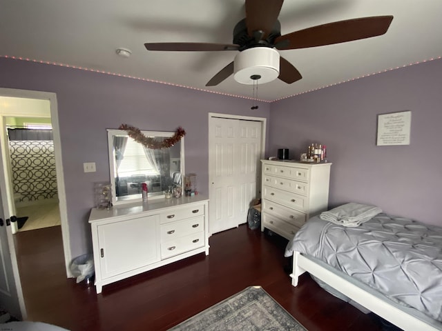 bedroom featuring a closet, dark wood-style flooring, and a ceiling fan