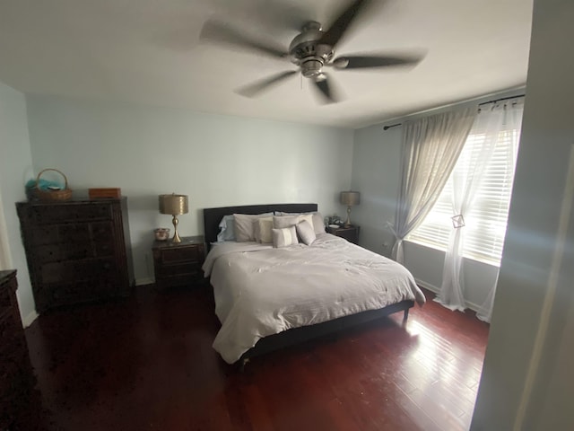 bedroom featuring a ceiling fan, dark wood-style flooring, and baseboards