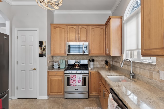 kitchen featuring appliances with stainless steel finishes, a sink, ornamental molding, and light stone countertops