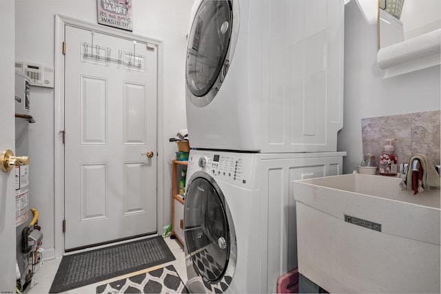 clothes washing area featuring a sink, laundry area, and stacked washer / dryer