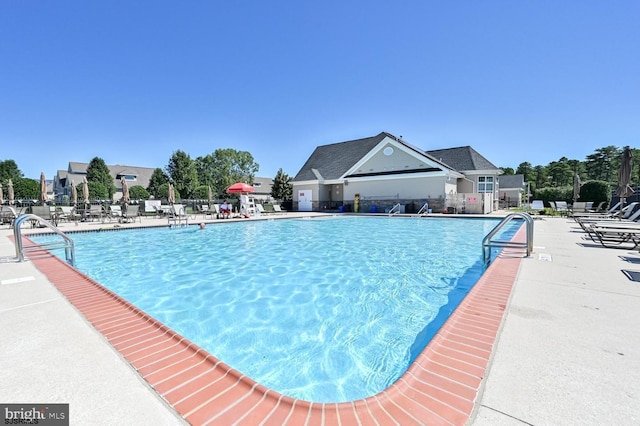 view of swimming pool with fence and a patio