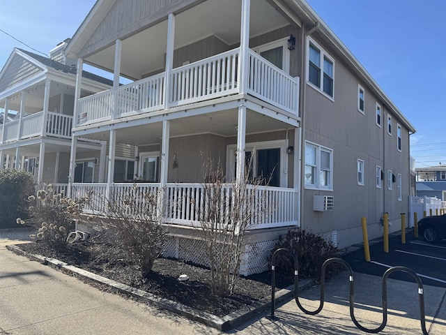 view of side of property with crawl space, covered porch, and a balcony