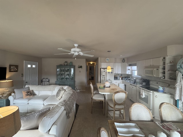 living room featuring ceiling fan and dark tile patterned floors