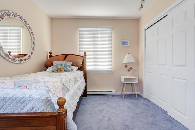 bedroom with light carpet, baseboards, baseboard heating, a closet, and rail lighting