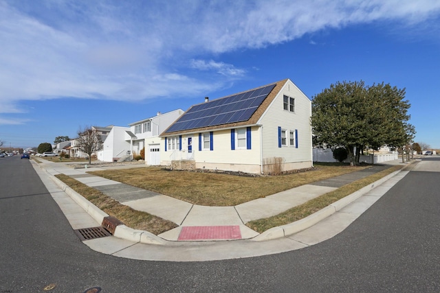 view of front of home with a residential view and solar panels