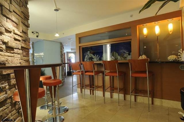 bar with hanging light fixtures, a dry bar, and tile patterned floors