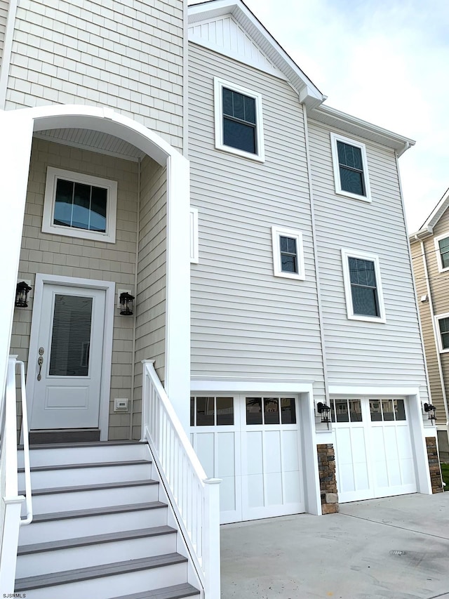 exterior space with board and batten siding, concrete driveway, and a garage