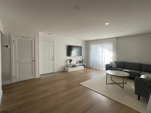 living area with visible vents, wood finished floors, and recessed lighting