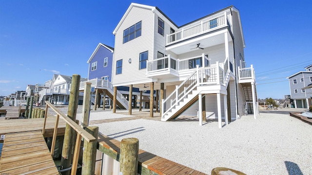 back of property featuring a sunroom, ceiling fan, a residential view, and stairway