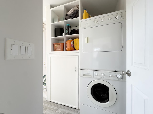 washroom with stacked washer and dryer and cabinet space