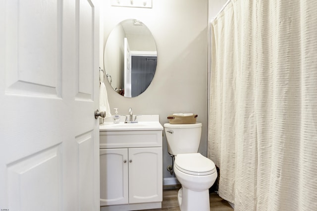 bathroom featuring toilet, wood finished floors, and vanity