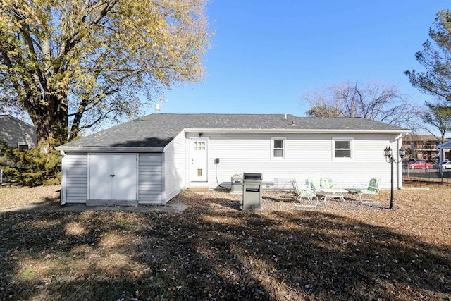 back of property with an outbuilding and a storage shed