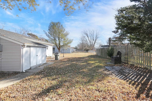 view of yard with an outbuilding, a storage shed, and a fenced backyard