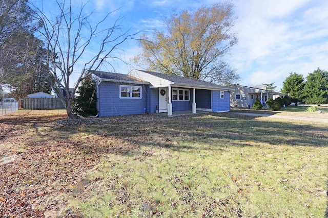 ranch-style house featuring a front yard and fence