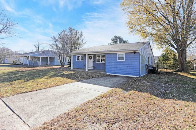 ranch-style home featuring a shingled roof and a front yard