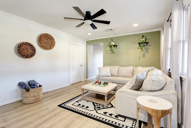 living room with a ceiling fan, baseboards, visible vents, light wood-style floors, and ornamental molding