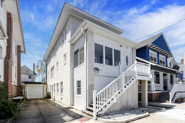 view of front facade featuring an outbuilding, stairway, and a garage