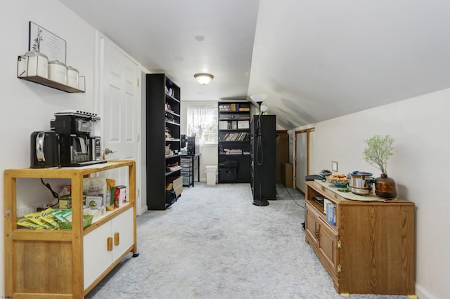 office area with vaulted ceiling and light colored carpet