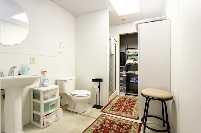 bathroom with visible vents, toilet, a stall shower, a sink, and tile patterned flooring