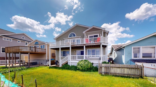 view of front of home with a balcony, fence, and a front lawn