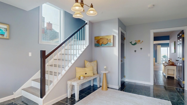 staircase with baseboards and an inviting chandelier